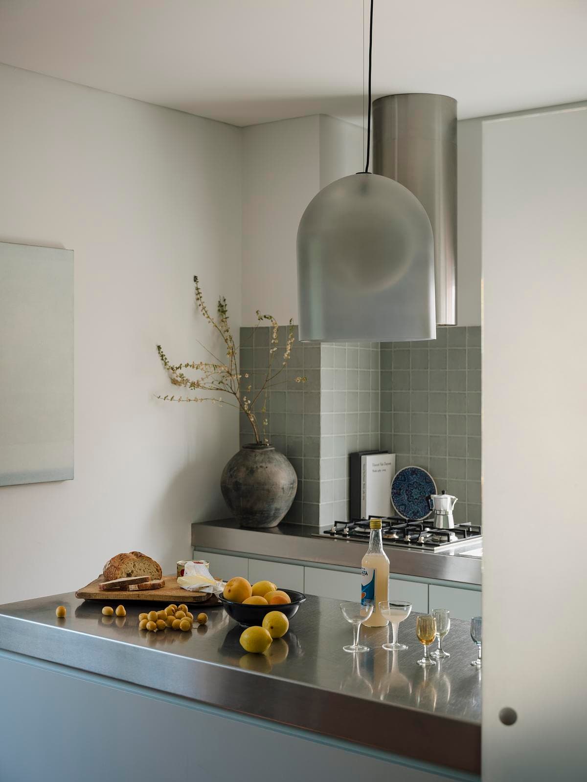 Blue-grey cabinetry beneath the kitchen’s retained steel benchtop