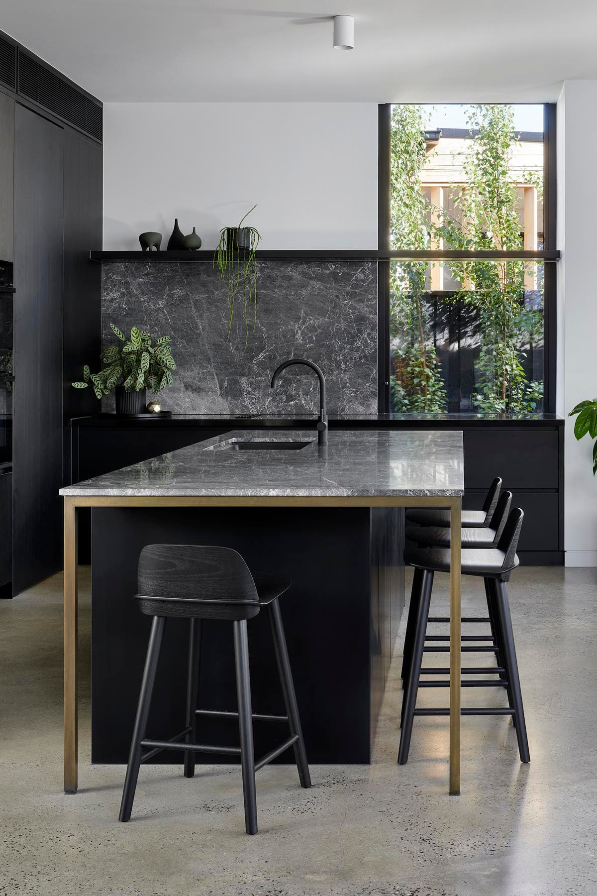 Dark cabinetry and a stone island in the kitchen.