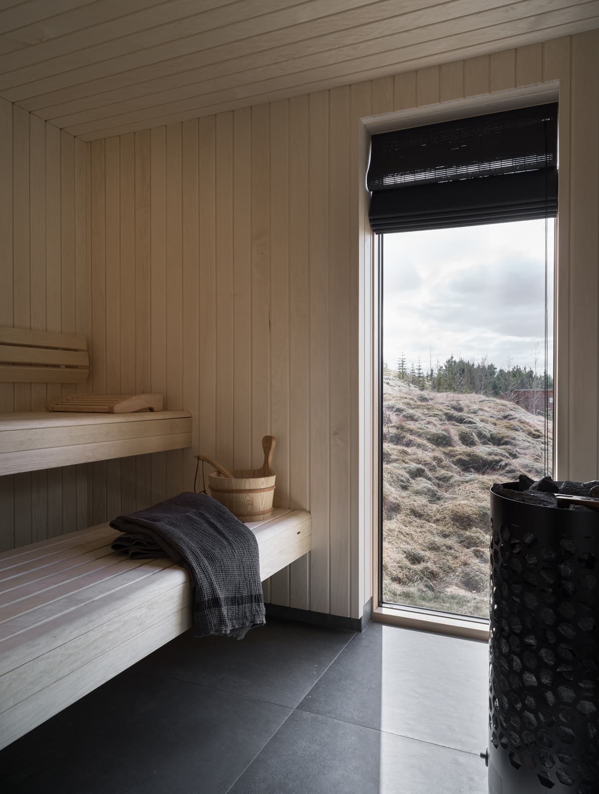 A timber-lined room and built-in bench face the landscape.