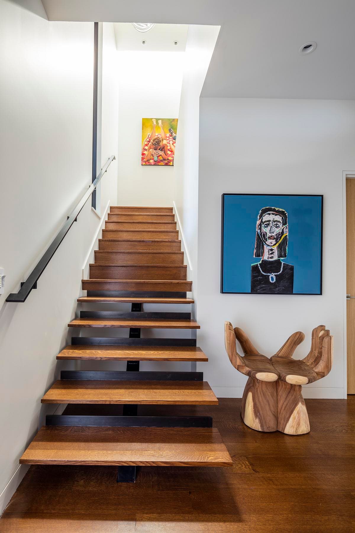 The stair rises beside artwork and a roof light