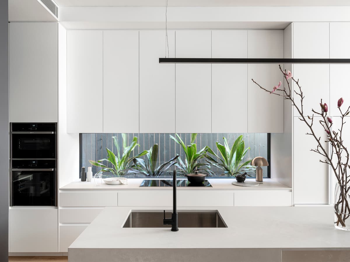 A garden-facing splashback window brings light and planting into the kitchen.