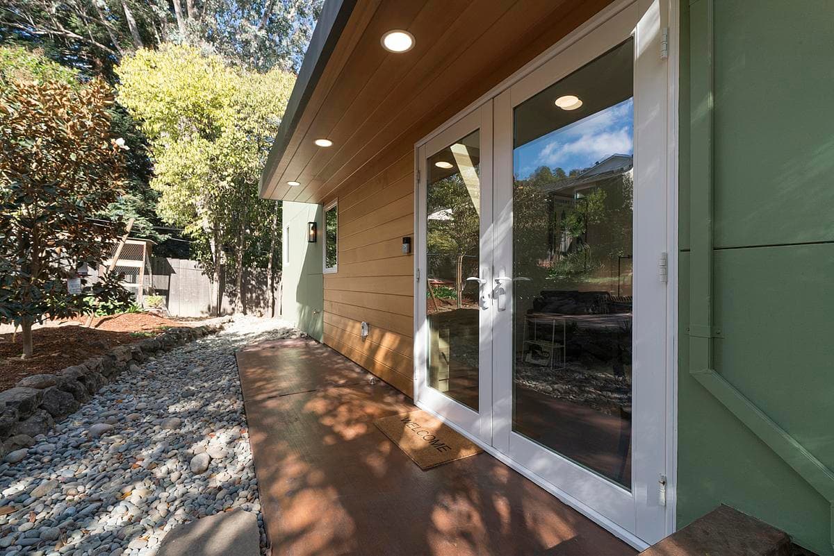 A covered entrance and glazed doors connect the home with the garden.