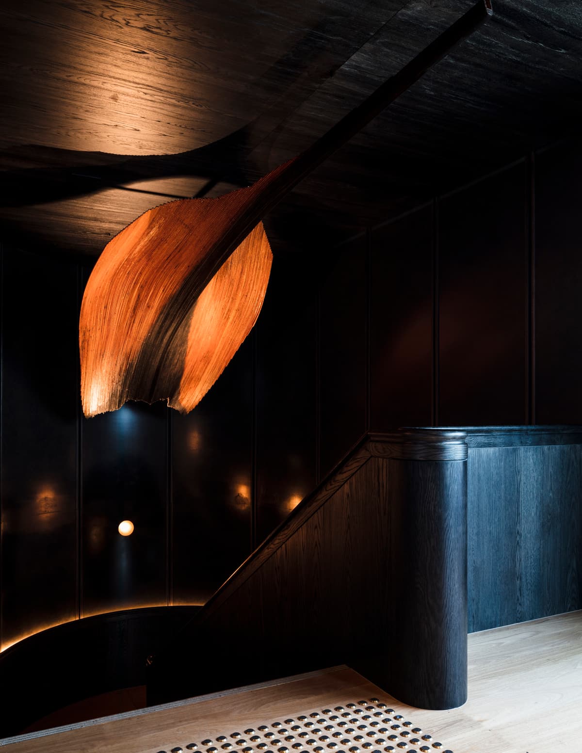 Dark finishes and warm lighting mark the transition between venue spaces.