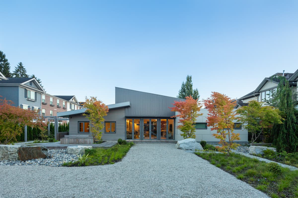 The garden opens towards the house’s glazed rear elevation.