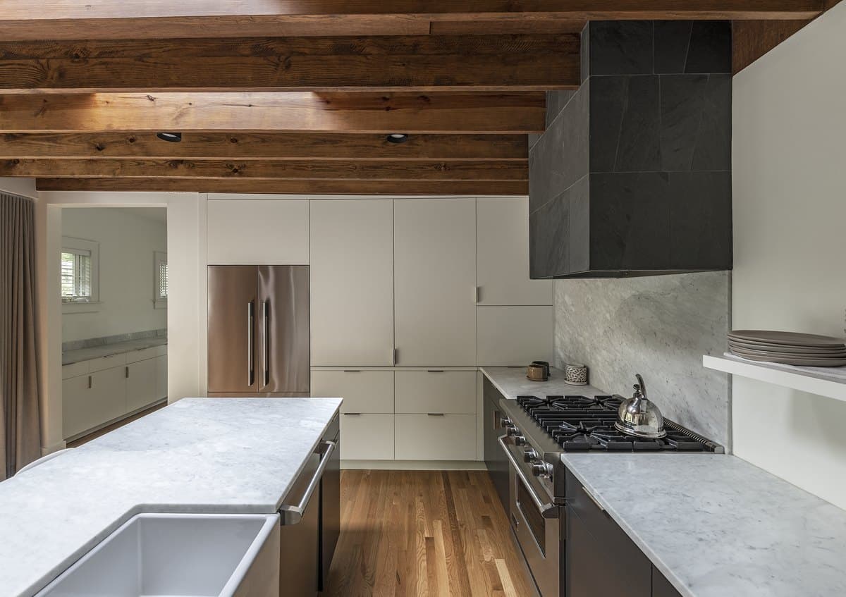 Ormewood Park Residence: kitchen island beneath exposed roof framing