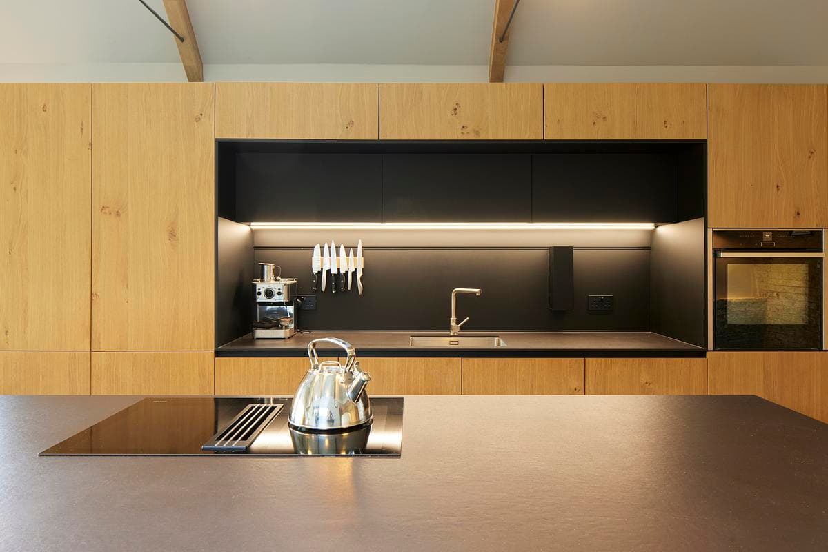 Oak cabinetry and a dark worktop in the new kitchen.