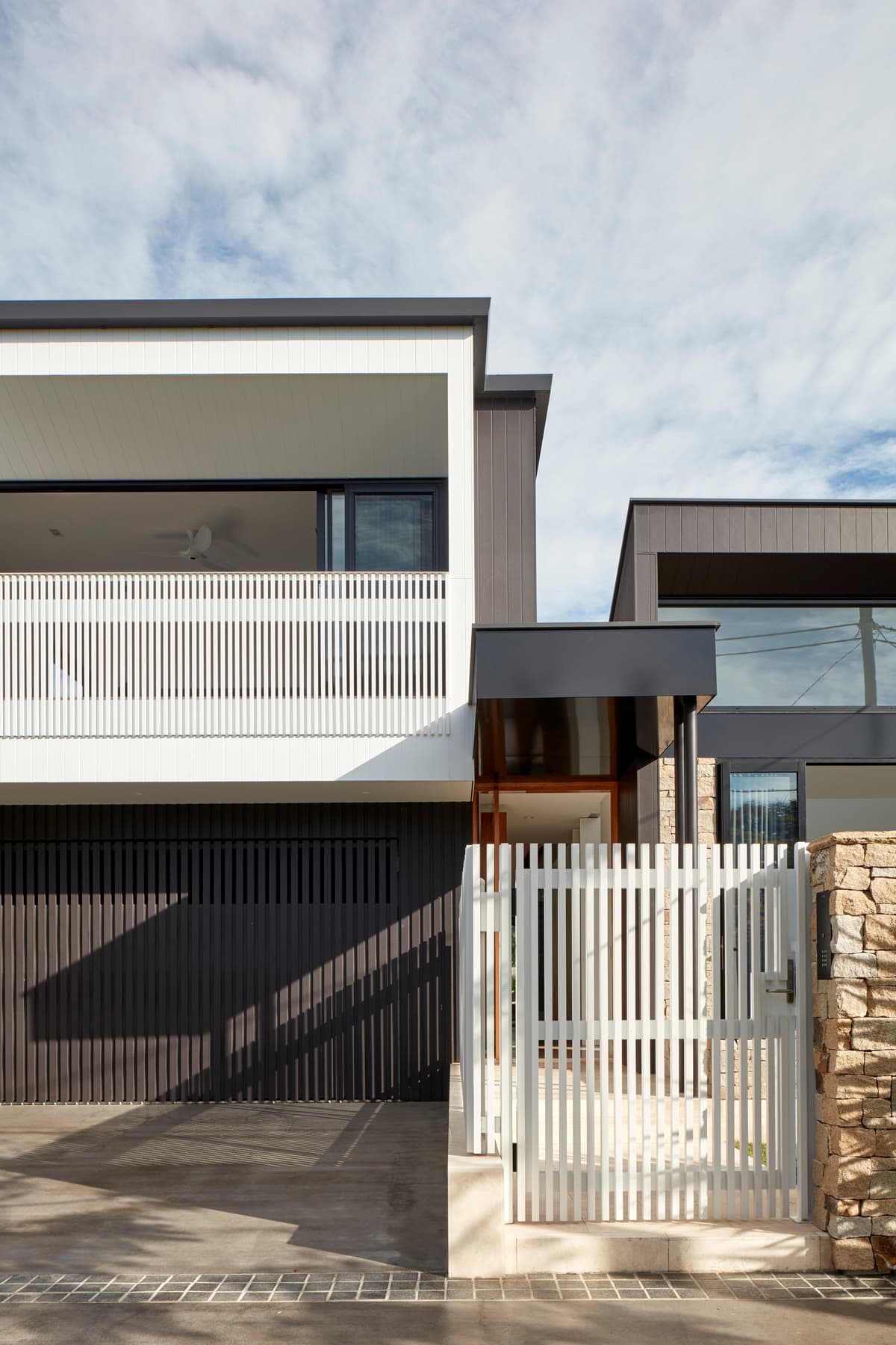 Screens, a balcony and deep openings form the street elevation.