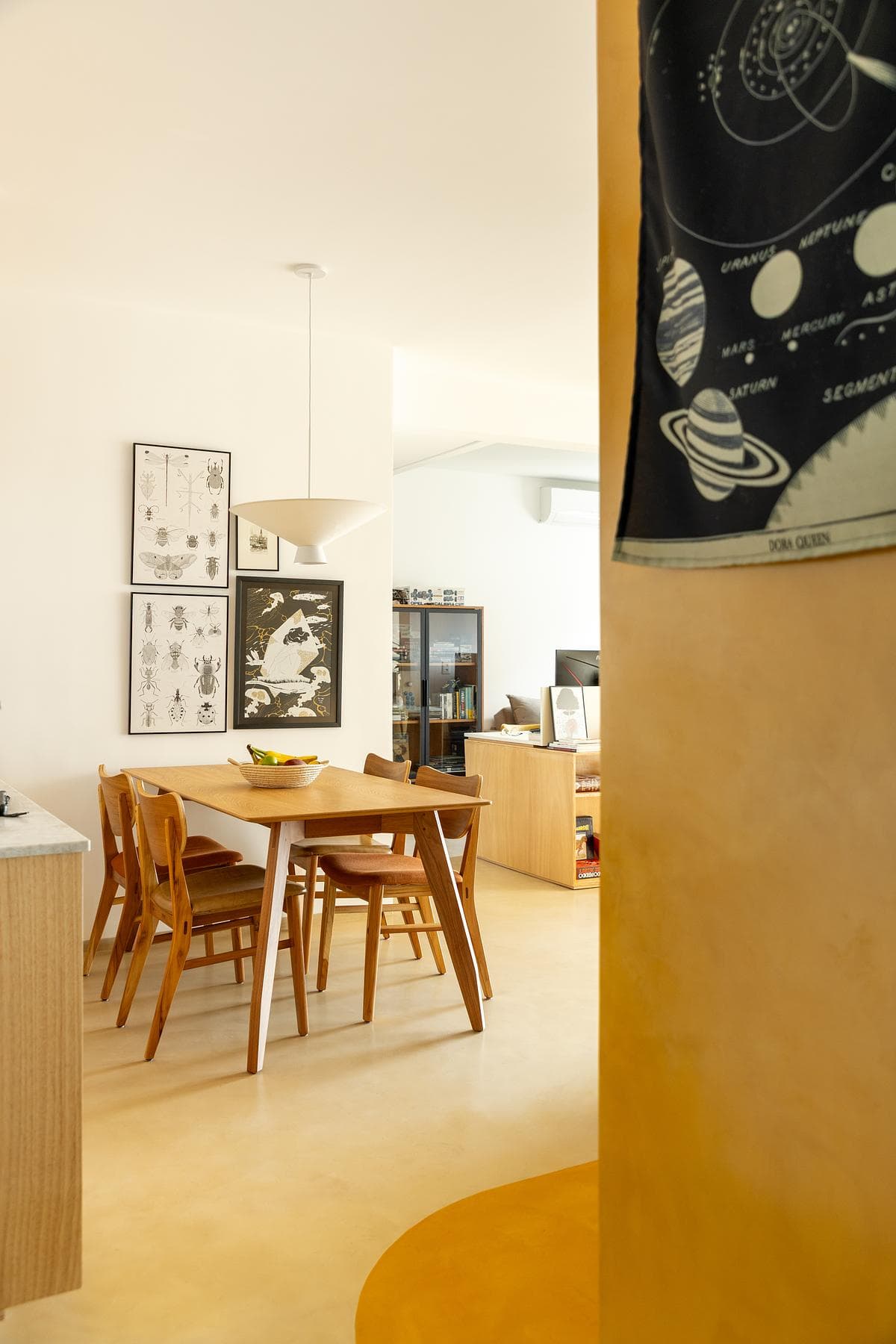 A curved line of yellow flooring leads towards the dining table.