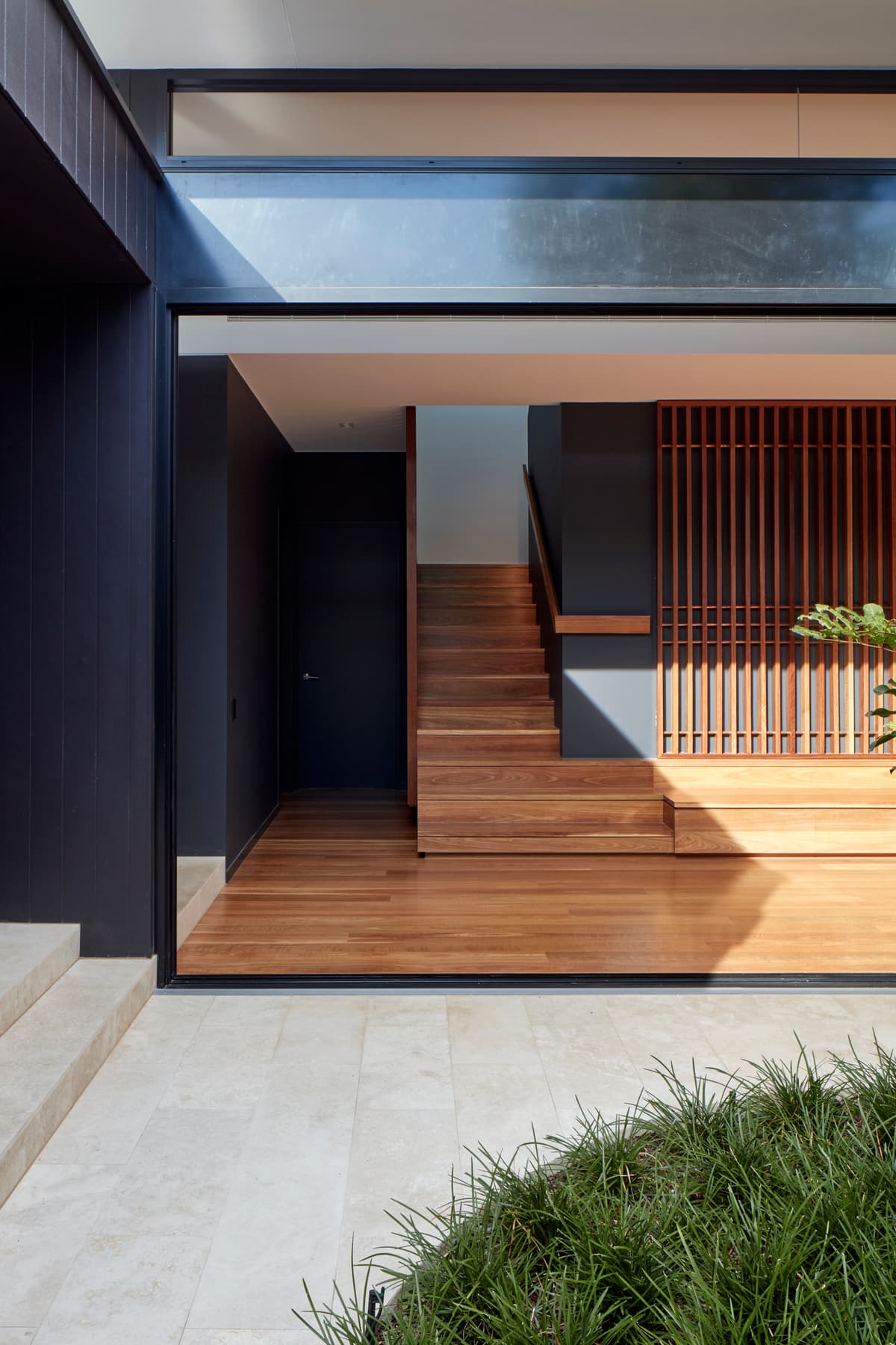 Timber steps and a vertical screen define the entrance and stair.