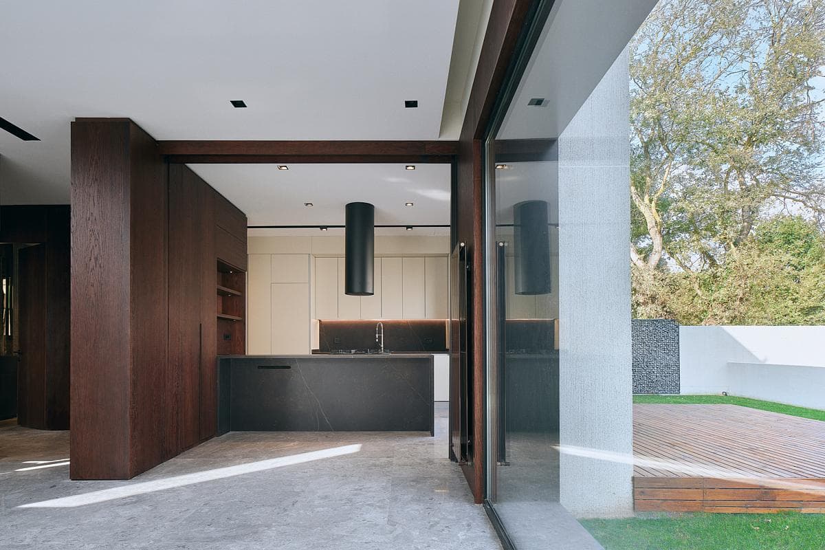 The kitchen opens towards a garden and outdoor deck.