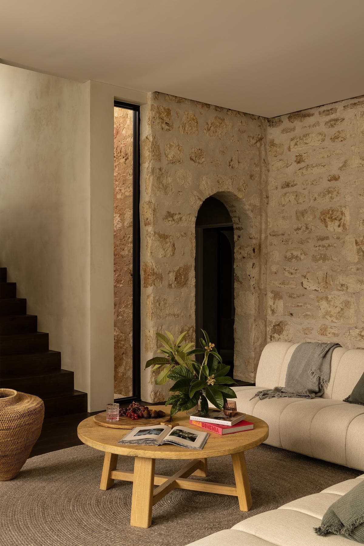 Exposed stone walls and an arched doorway give the older sitting room its character.