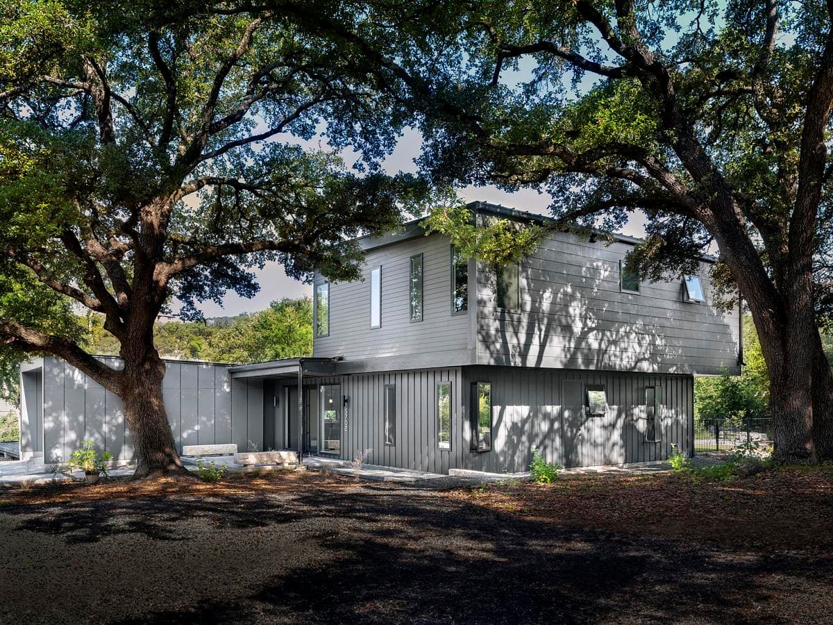 The house set beneath established live oak trees