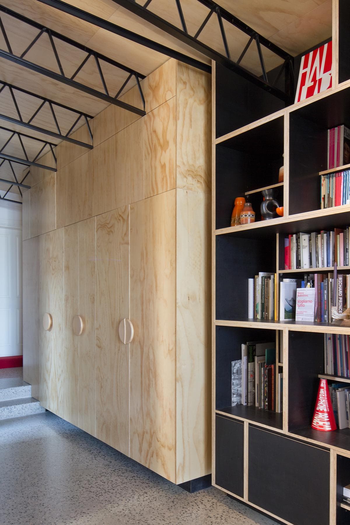 Full-height plywood joinery with built-in bookshelves.