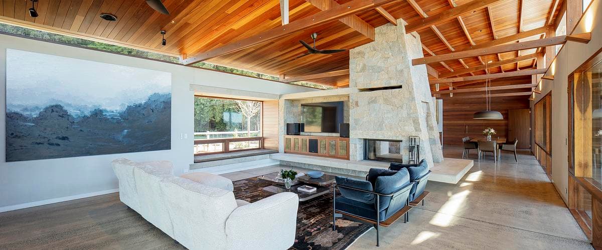 Living space with exposed timber structure and a central fireplace.