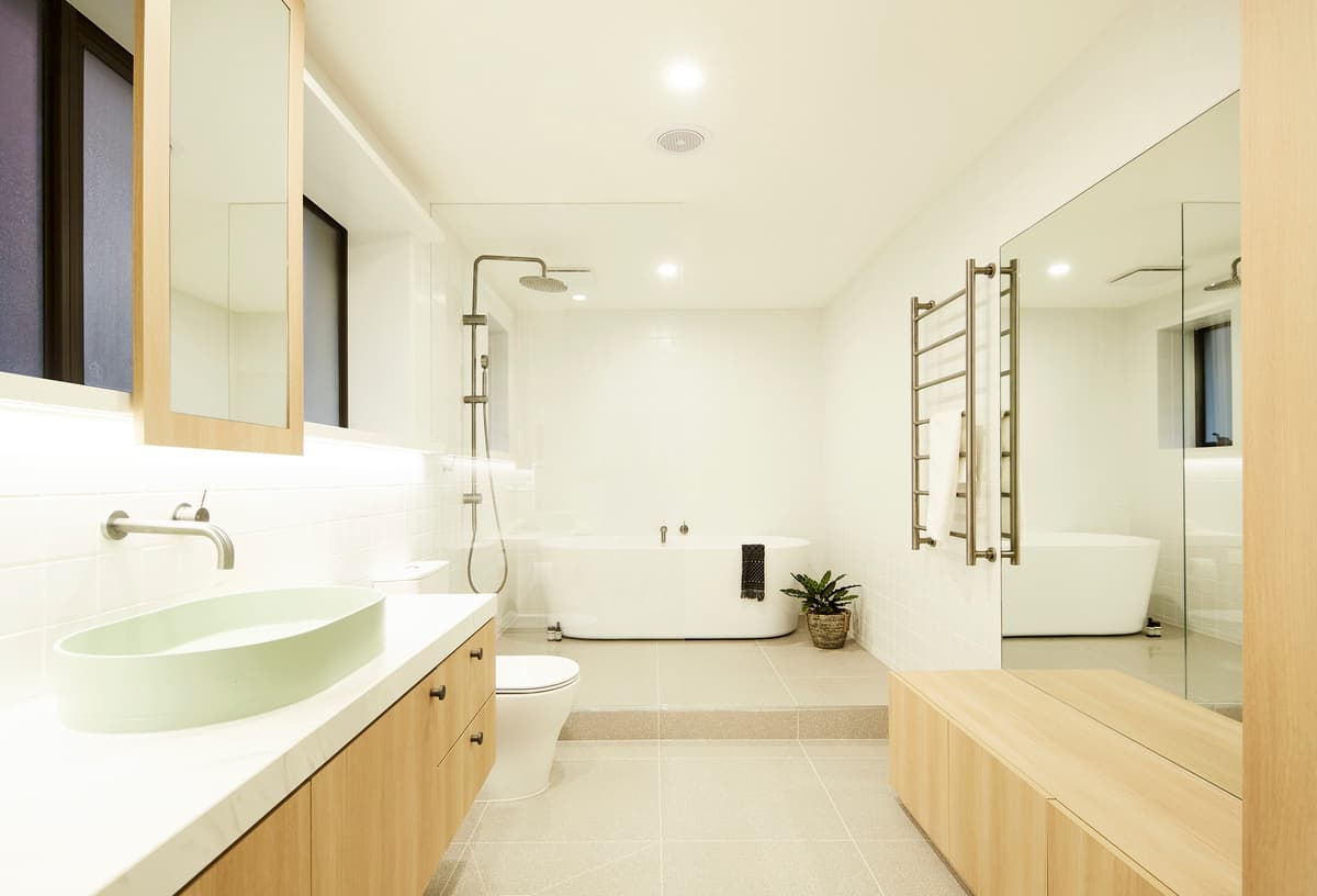 Light timber cabinetry and a long vanity in the bathroom.