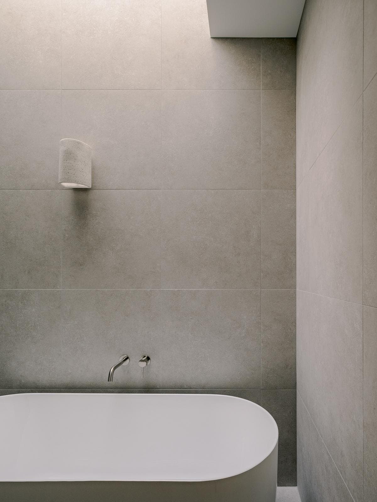 Freestanding bath and pale stone finishes