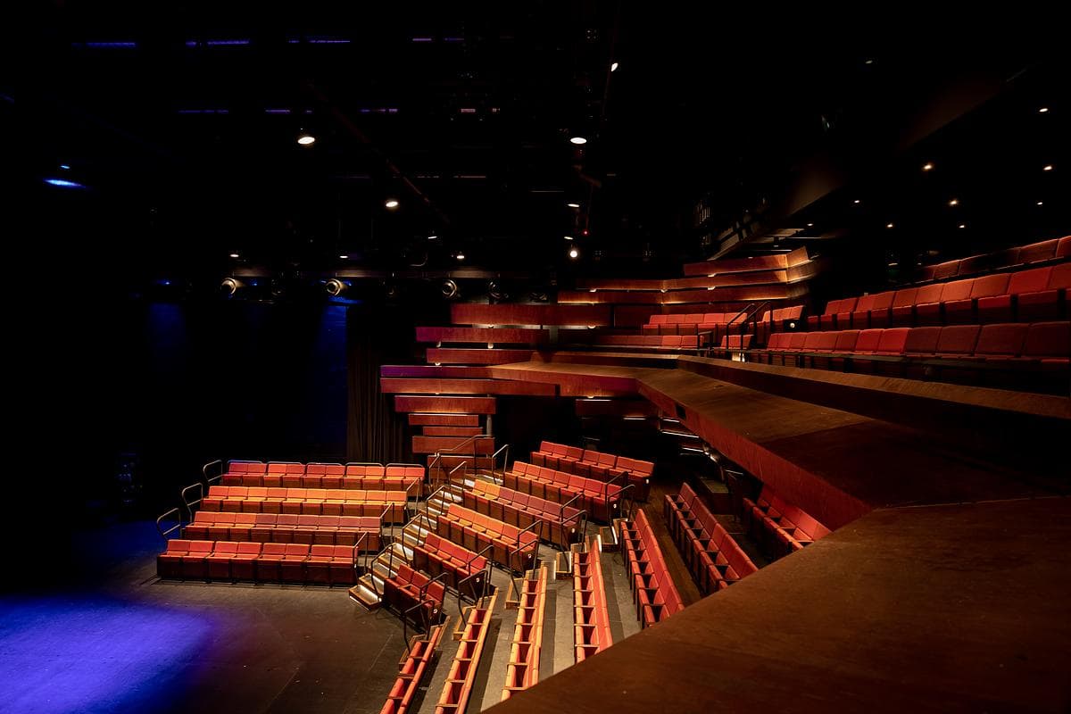 Red seating and layered balconies frame a performance space.