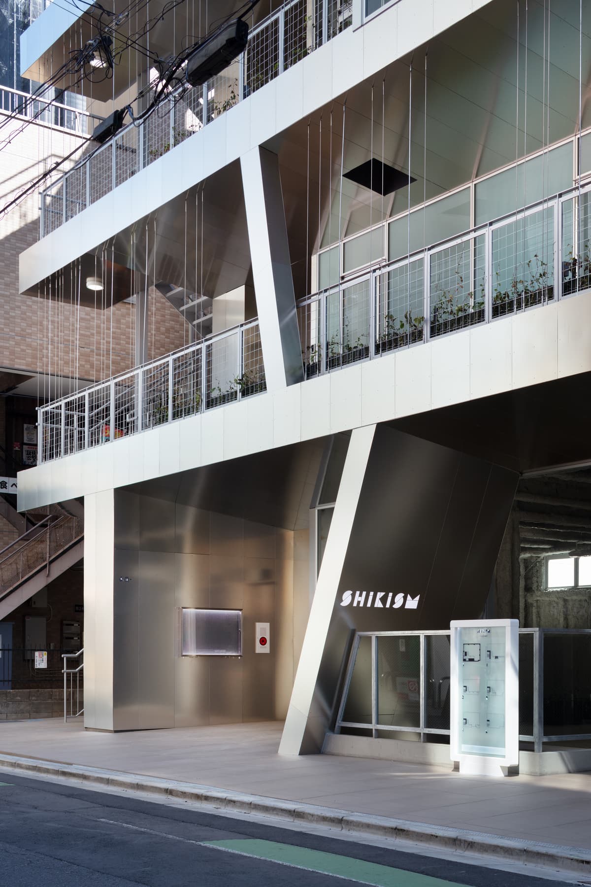 The entrance beneath an angled terrace wall