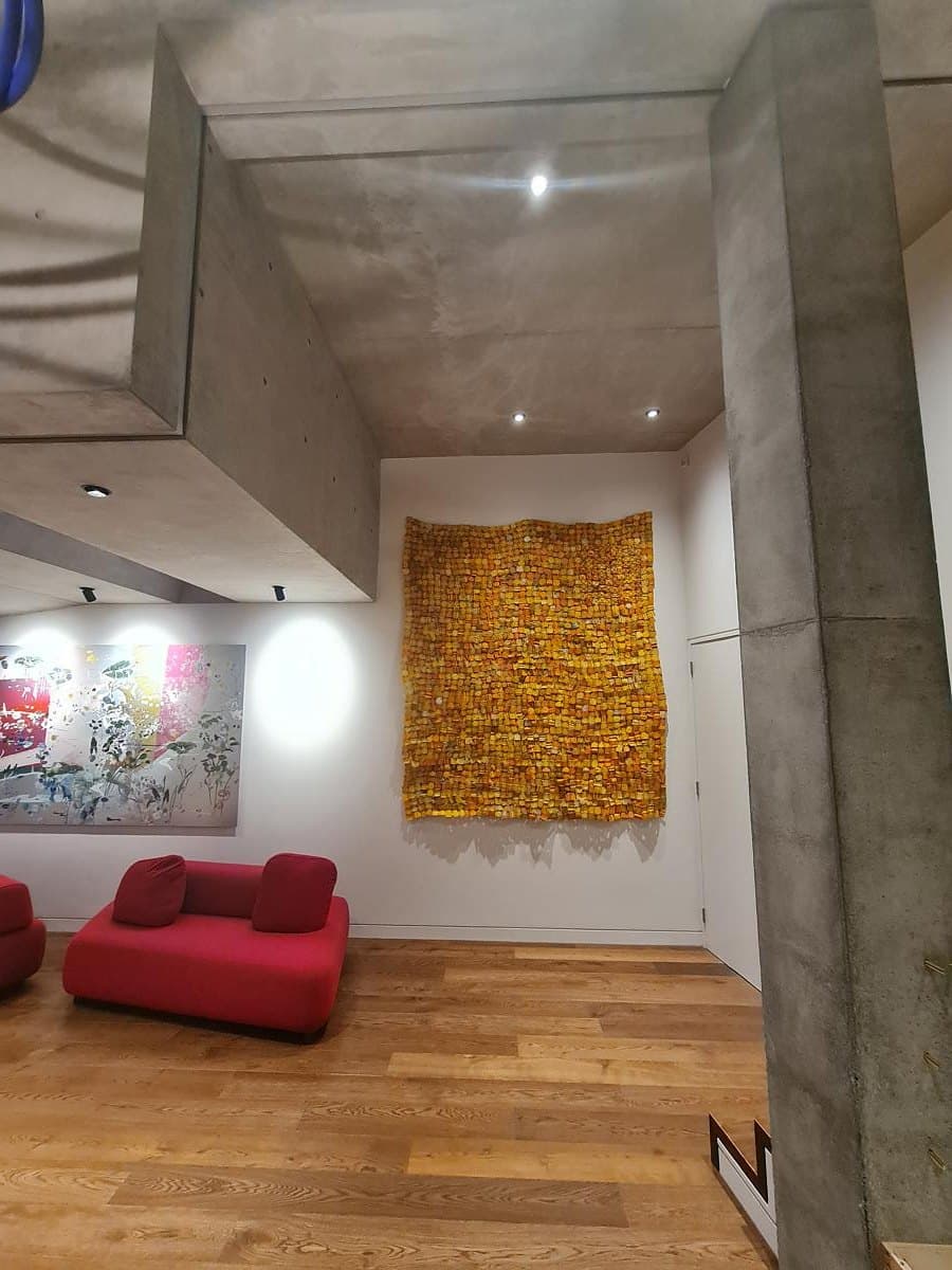 Exposed concrete and timber flooring frame a living space within the house.