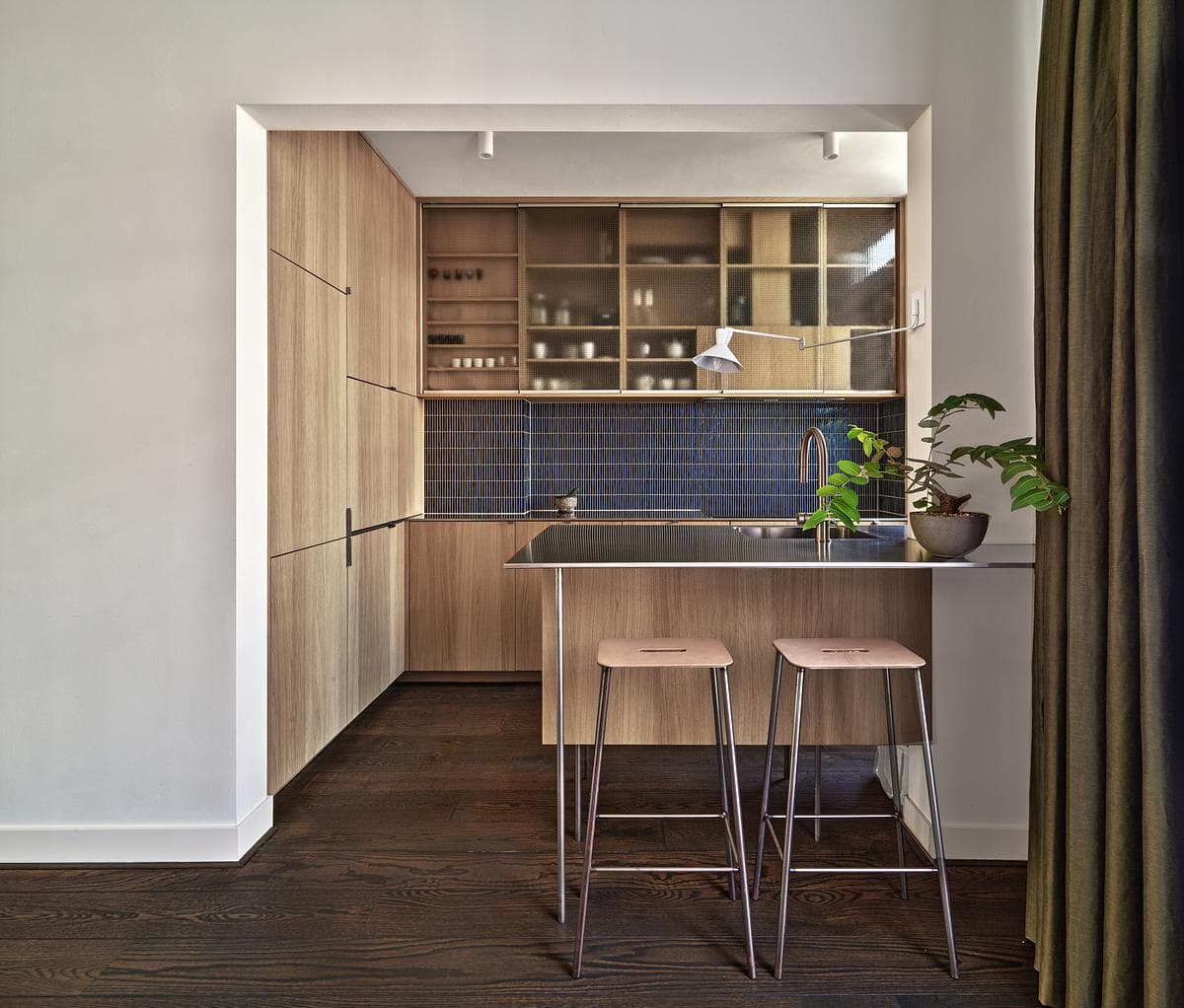 Oak kitchen joinery, blue tiles and a compact breakfast table