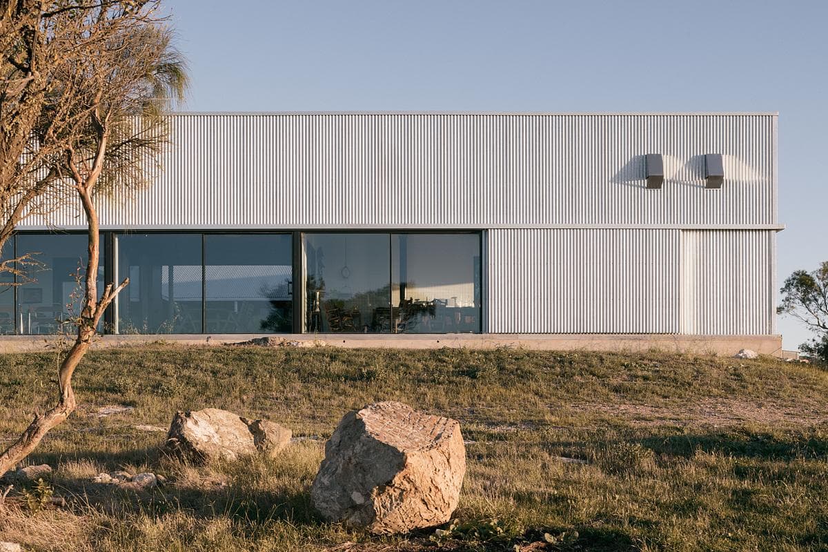A long glazed opening set within the corrugated-metal façade