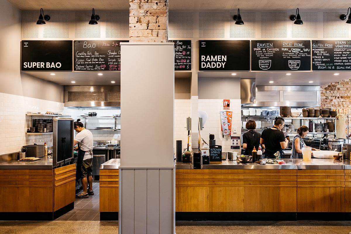 Open kitchen counter beneath the food hall menu boards