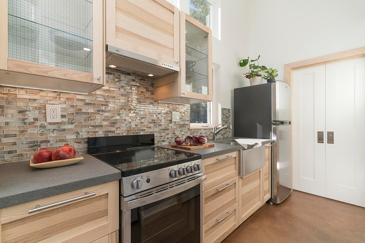 A galley kitchen combines fitted cabinetry, appliances and a tiled splashback.