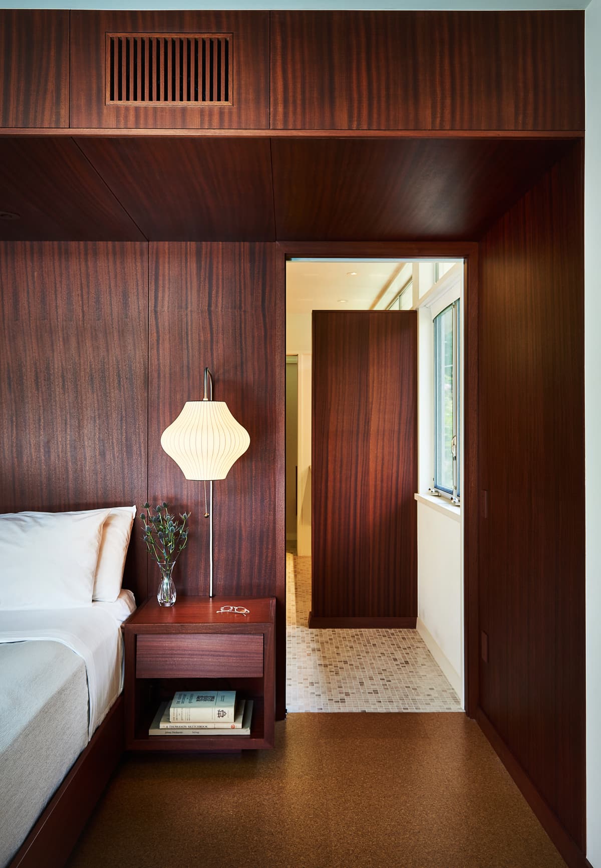Timber panelling and fitted joinery shape the bedroom.