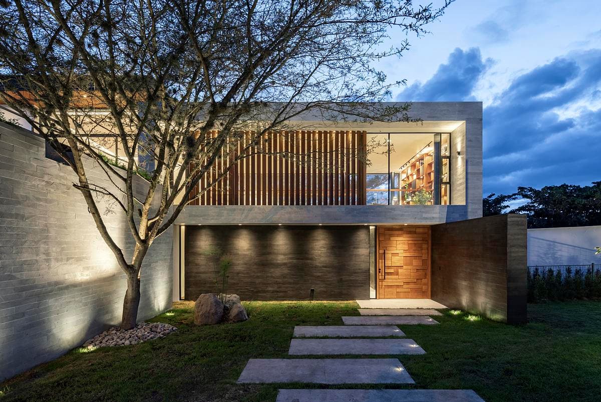 A planted approach leads beneath the projecting upper floor.