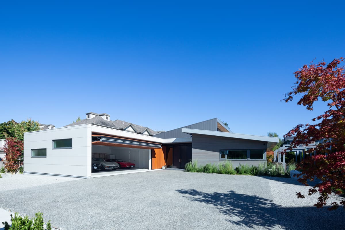 The wide entrance and timber garage door face the house’s suburban street.