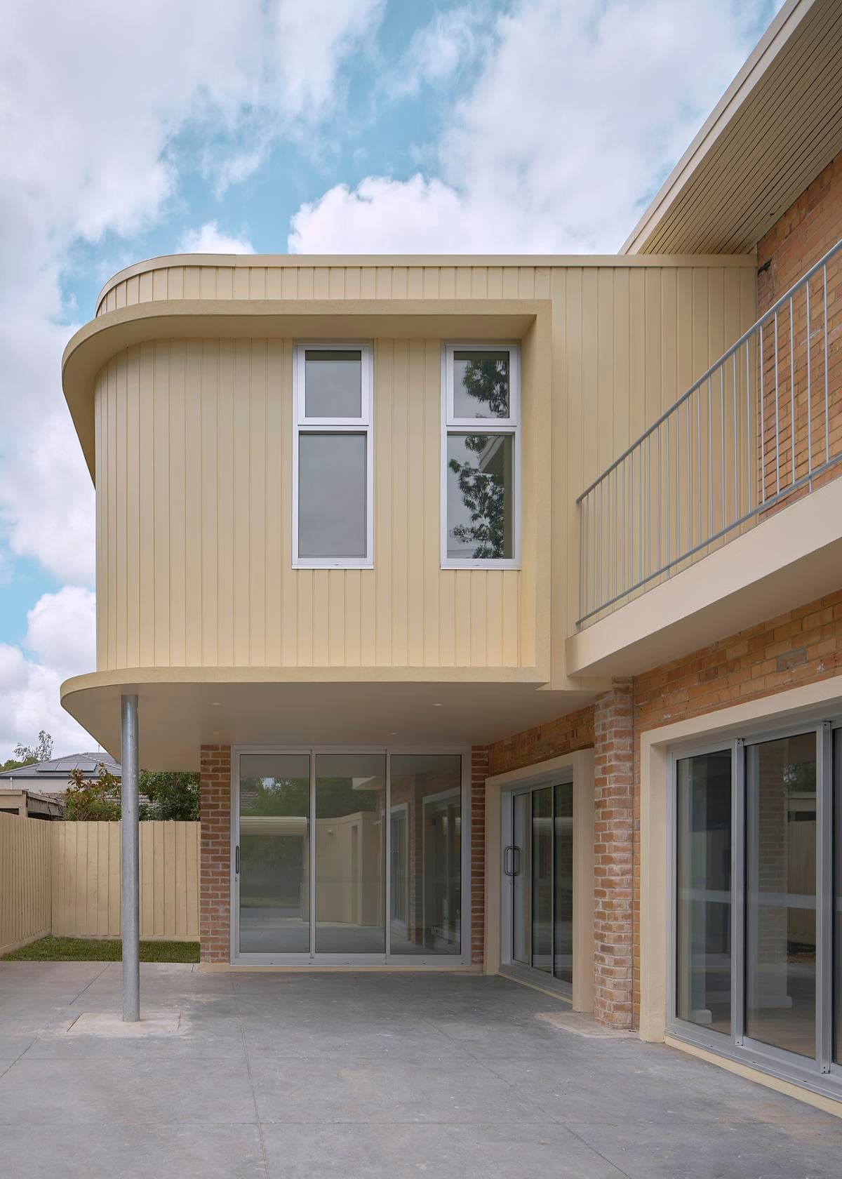 Curved facade, balcony and sheltered ground-floor space