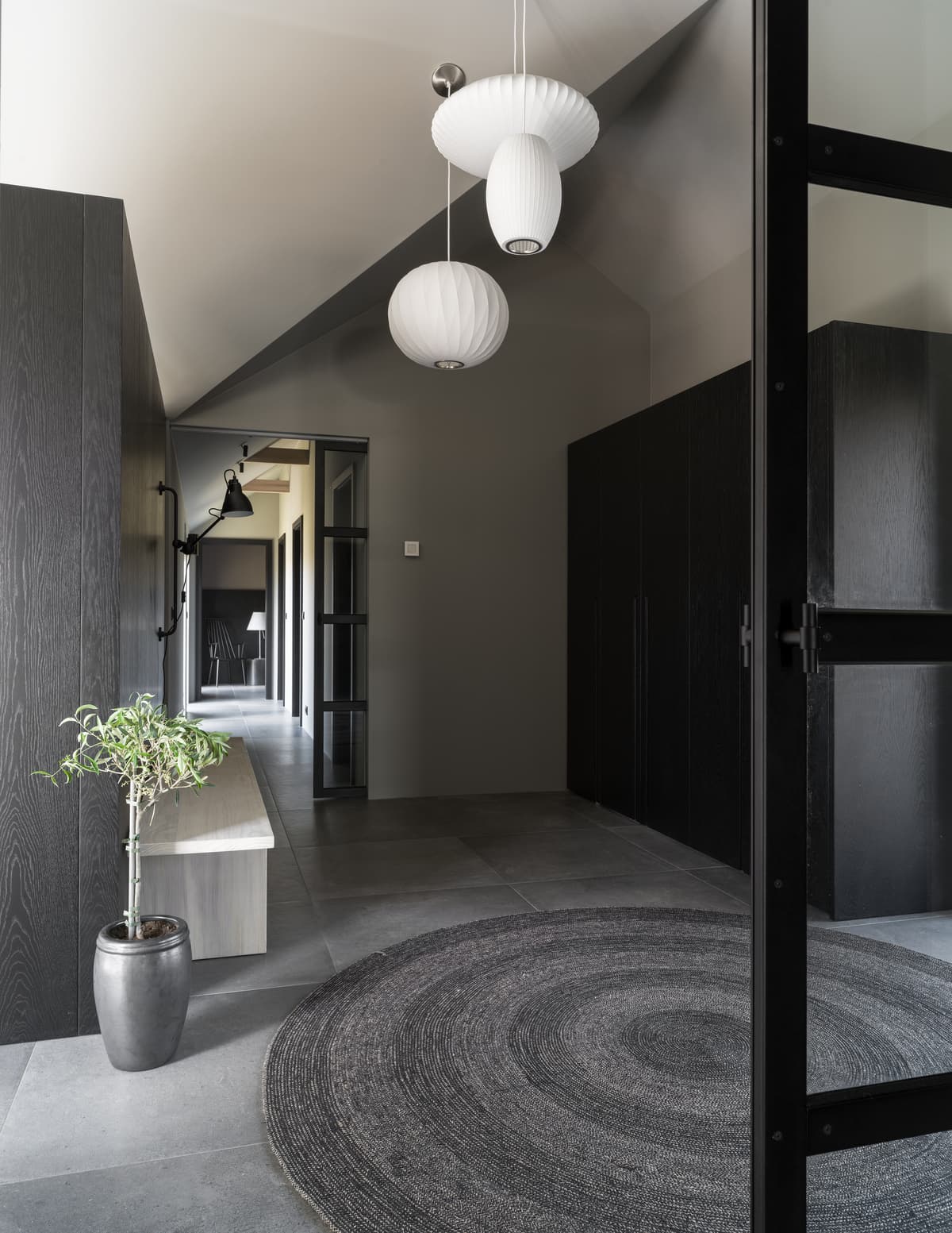 Pendant lights and a circular rug mark the entrance space.