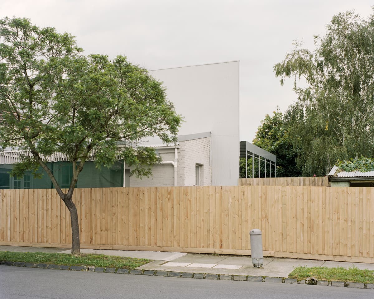 The addition sits quietly behind the timber boundary fence and existing trees.