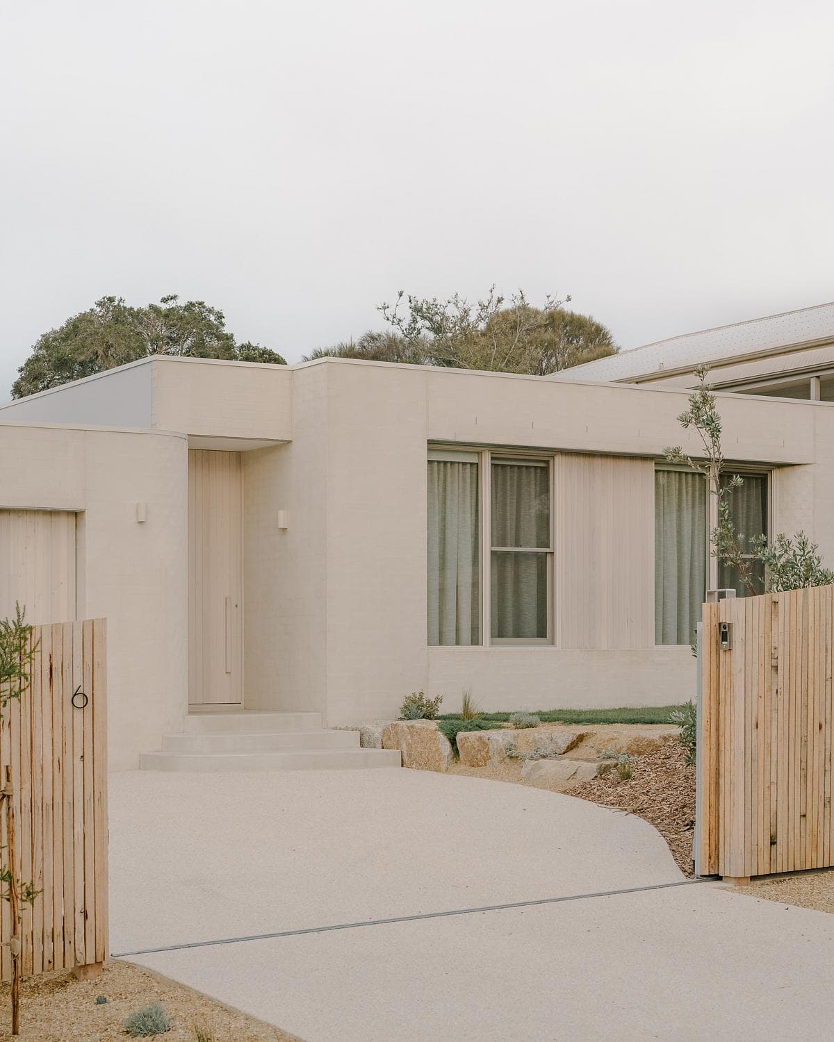 Curved entrance wall and front approach to the house