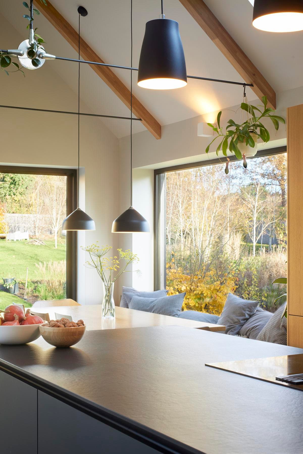 The kitchen opens towards a window seat overlooking the garden.