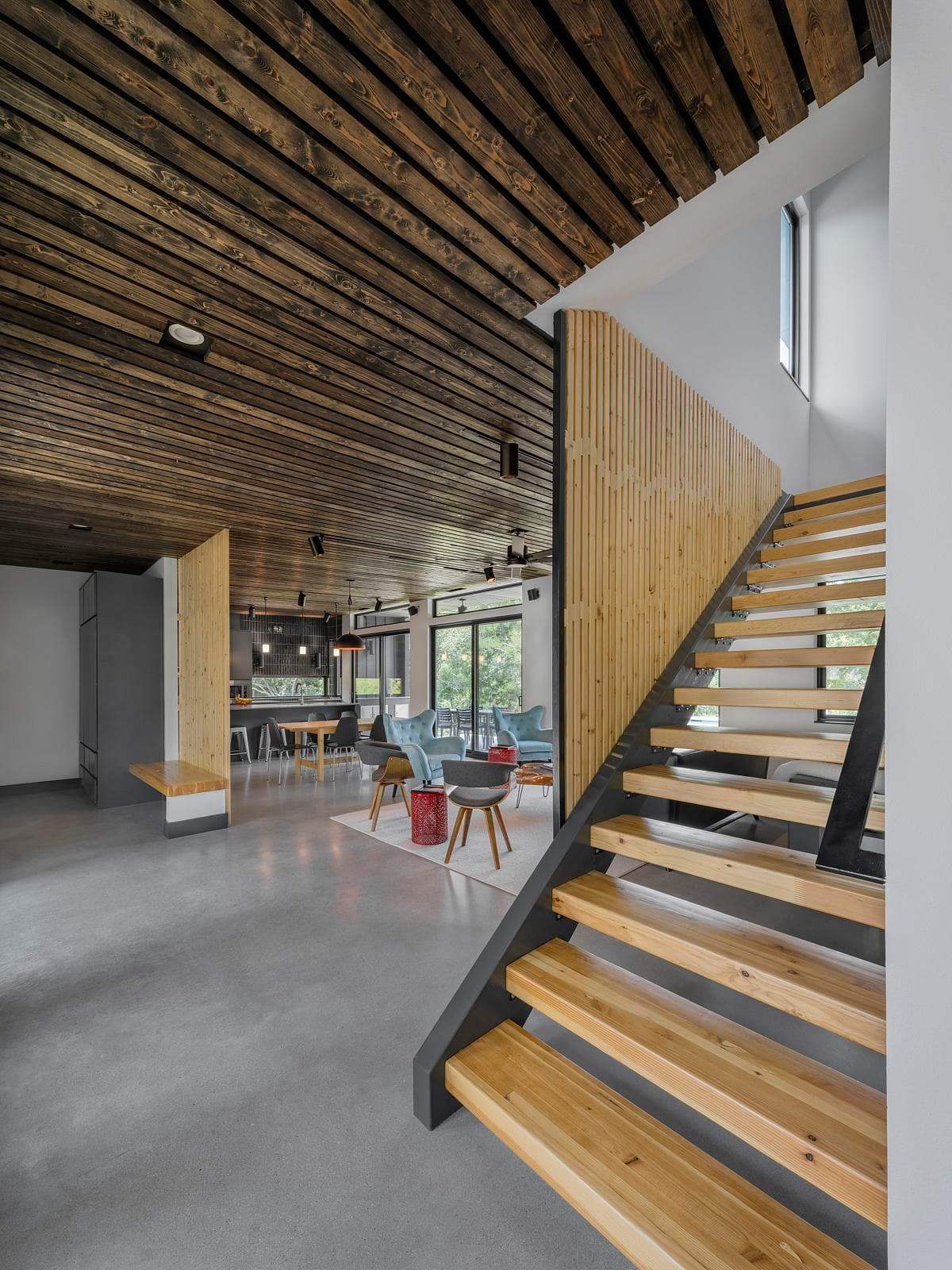 Open-riser stair beneath the timber-lined ceiling