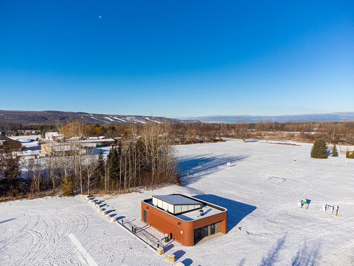 An aerial view in winter shows the pavilion beside the snow-covered fields.