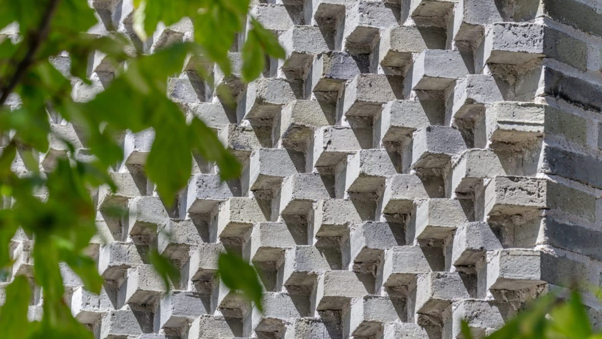 Sawtooth brickwork catches light across the facade