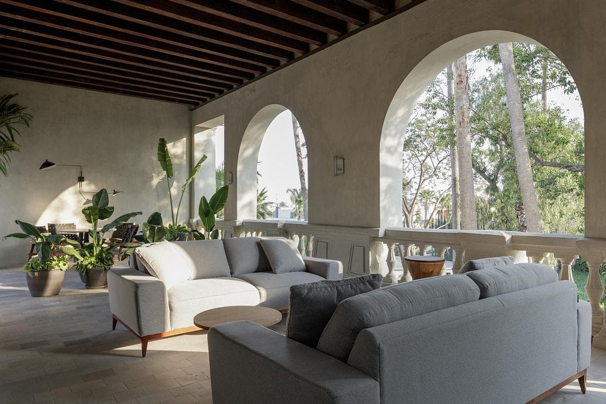 Loggia lounge framed by arched openings to the garden.