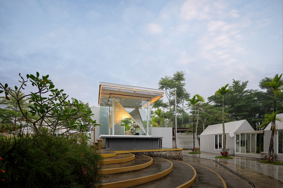 A daytime view places the small pavilion within its planted setting.