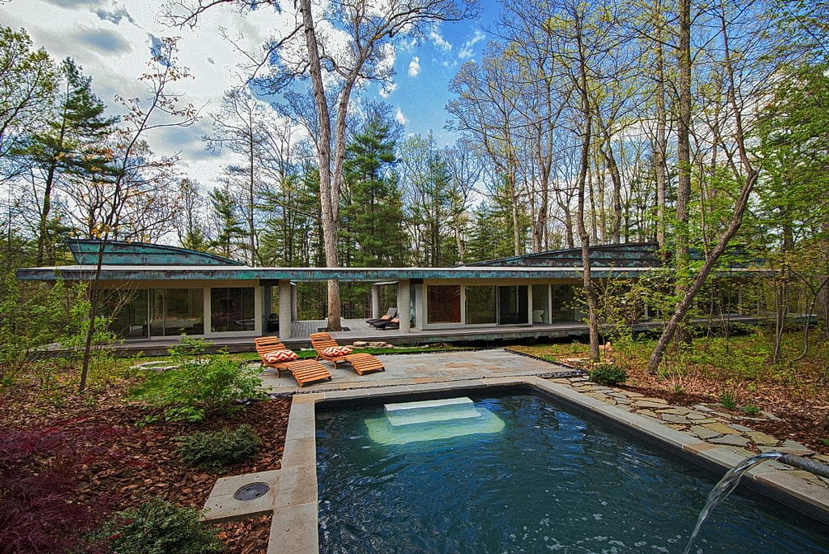 The pool terrace looks back towards the low woodland house.