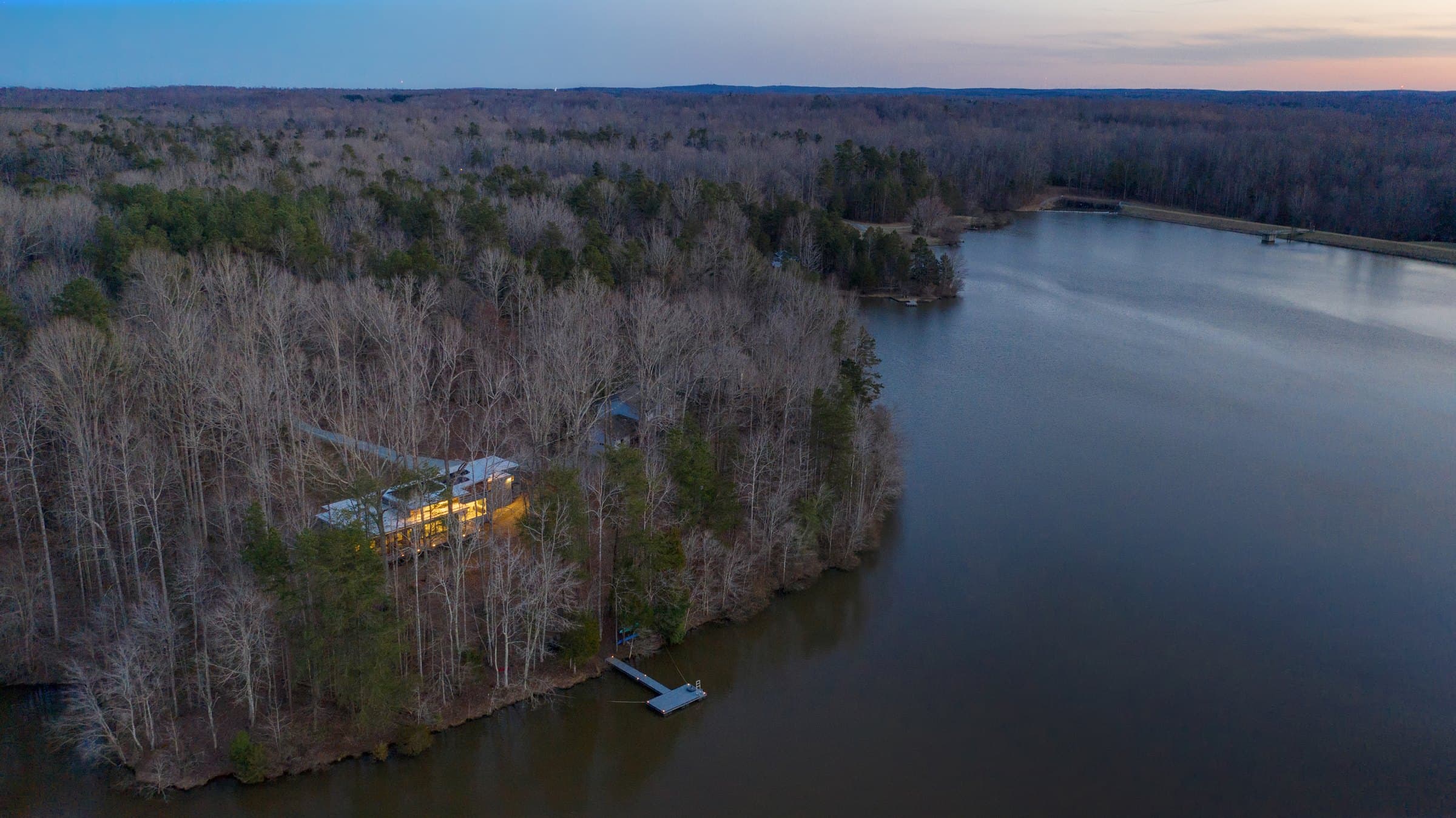 Aerial view showing the house on the wooded lakeshore