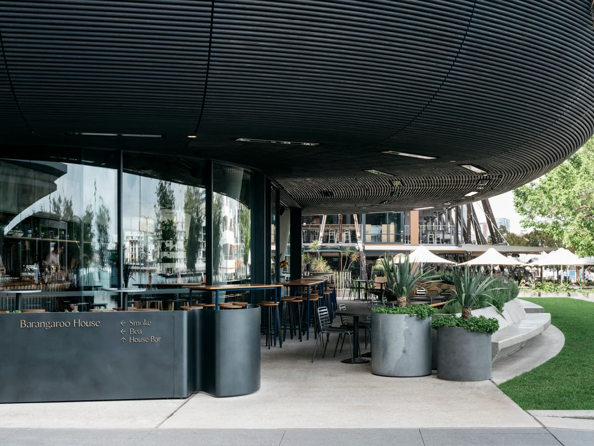 Outdoor seating and large planters extend the ground-floor venue towards the public precinct.