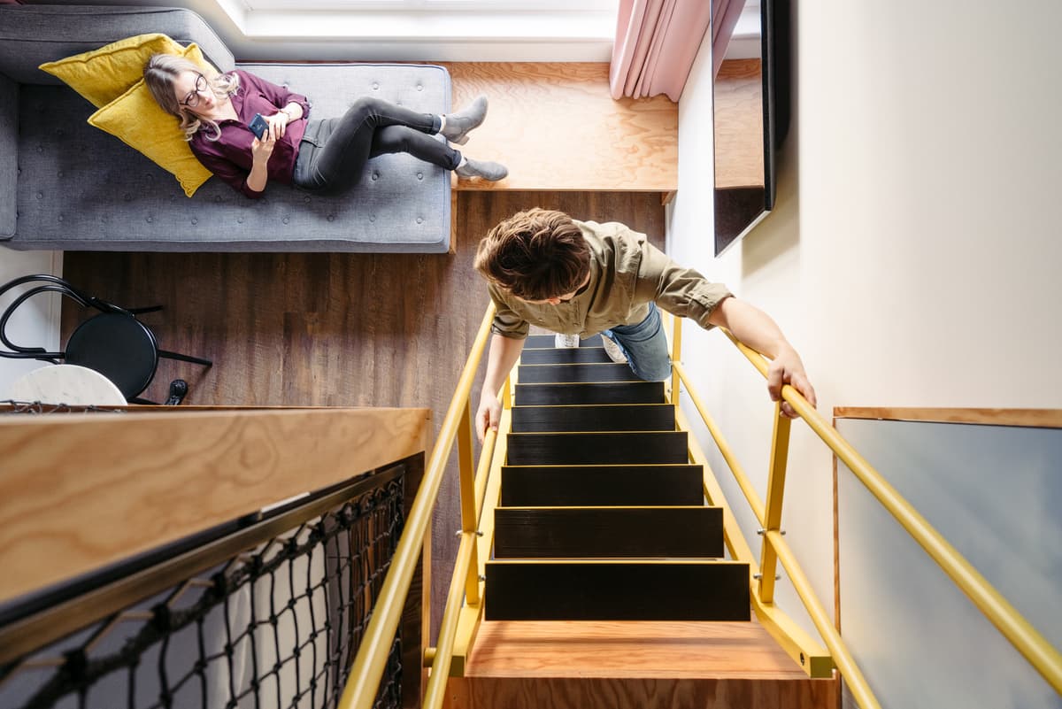 A stair connects the two levels of a maisonette guest room.