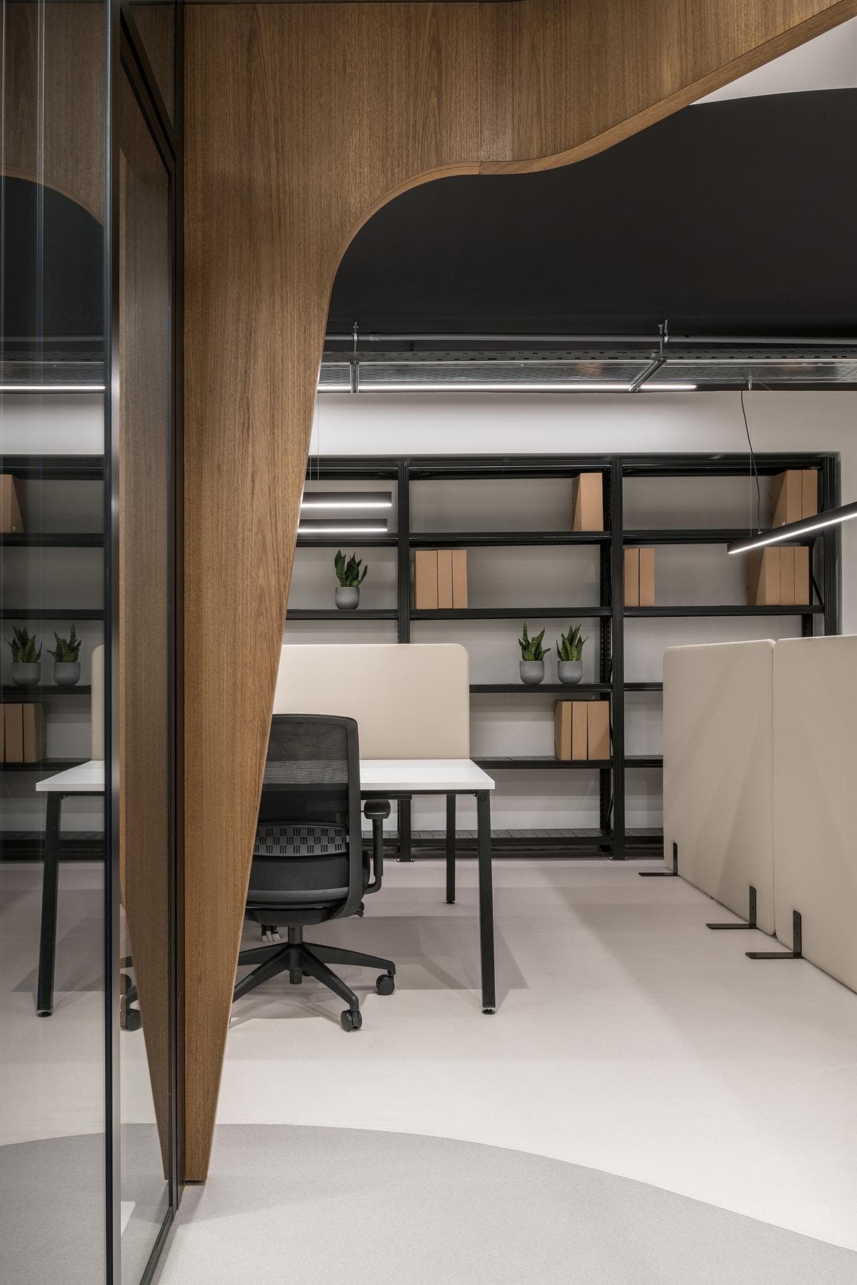 An opening in the timber wall leads into a quieter work area.