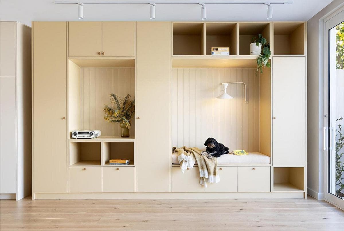 Pale built-in joinery includes an entrance bench.