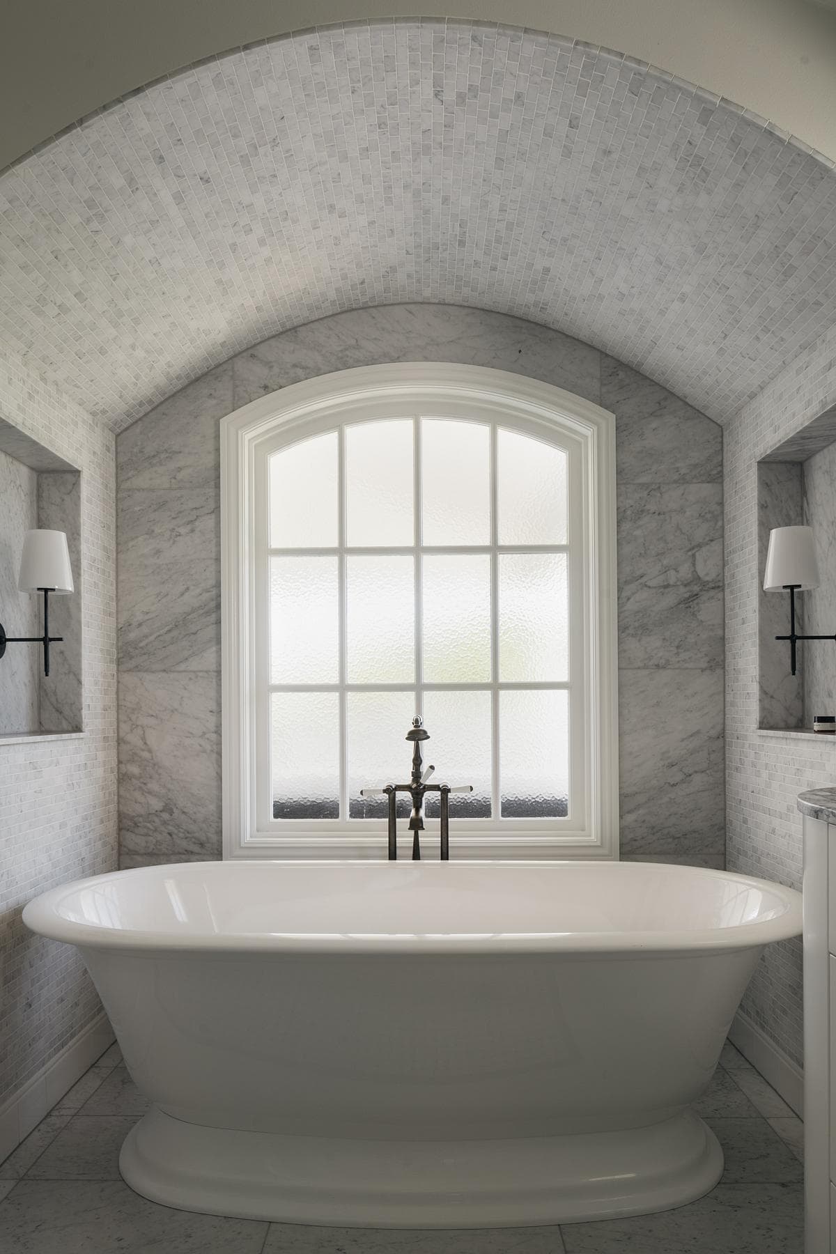 Benedictus Residence: freestanding bath beneath an arched window