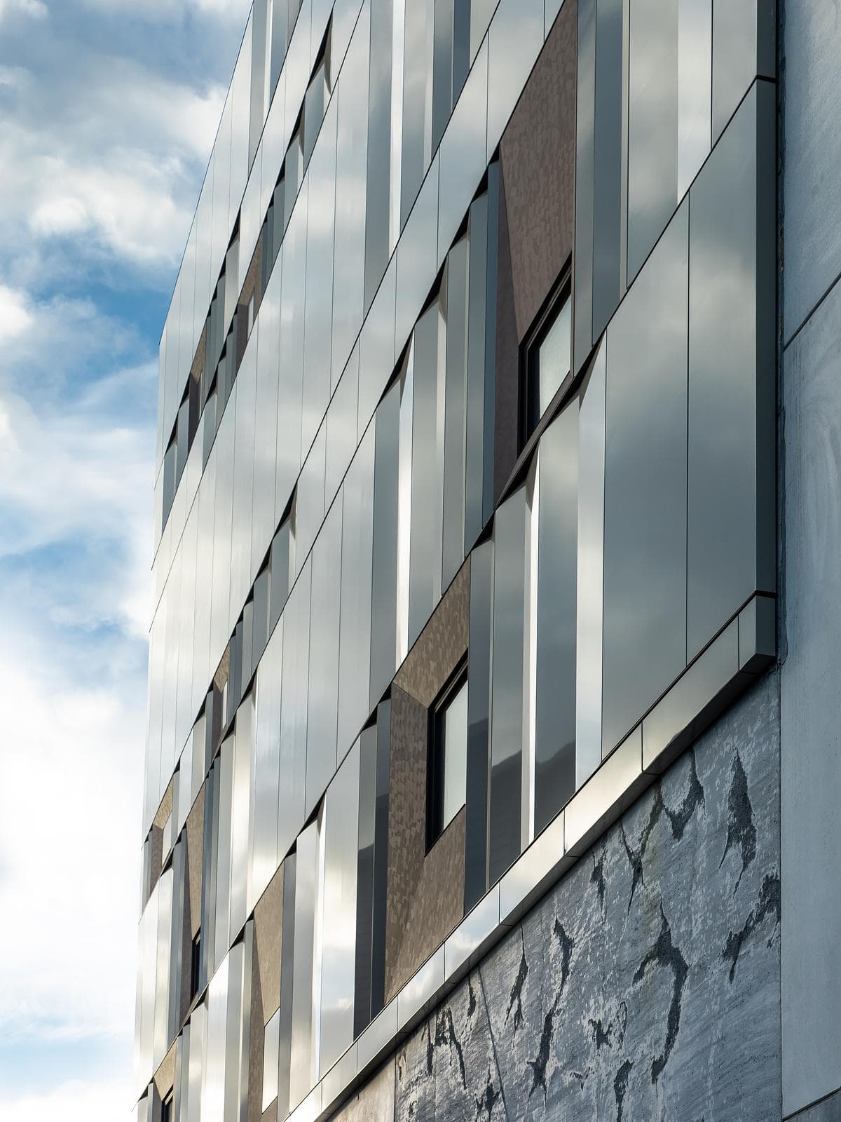 Metal cladding, glazing and retained masonry meet at the building’s edge.