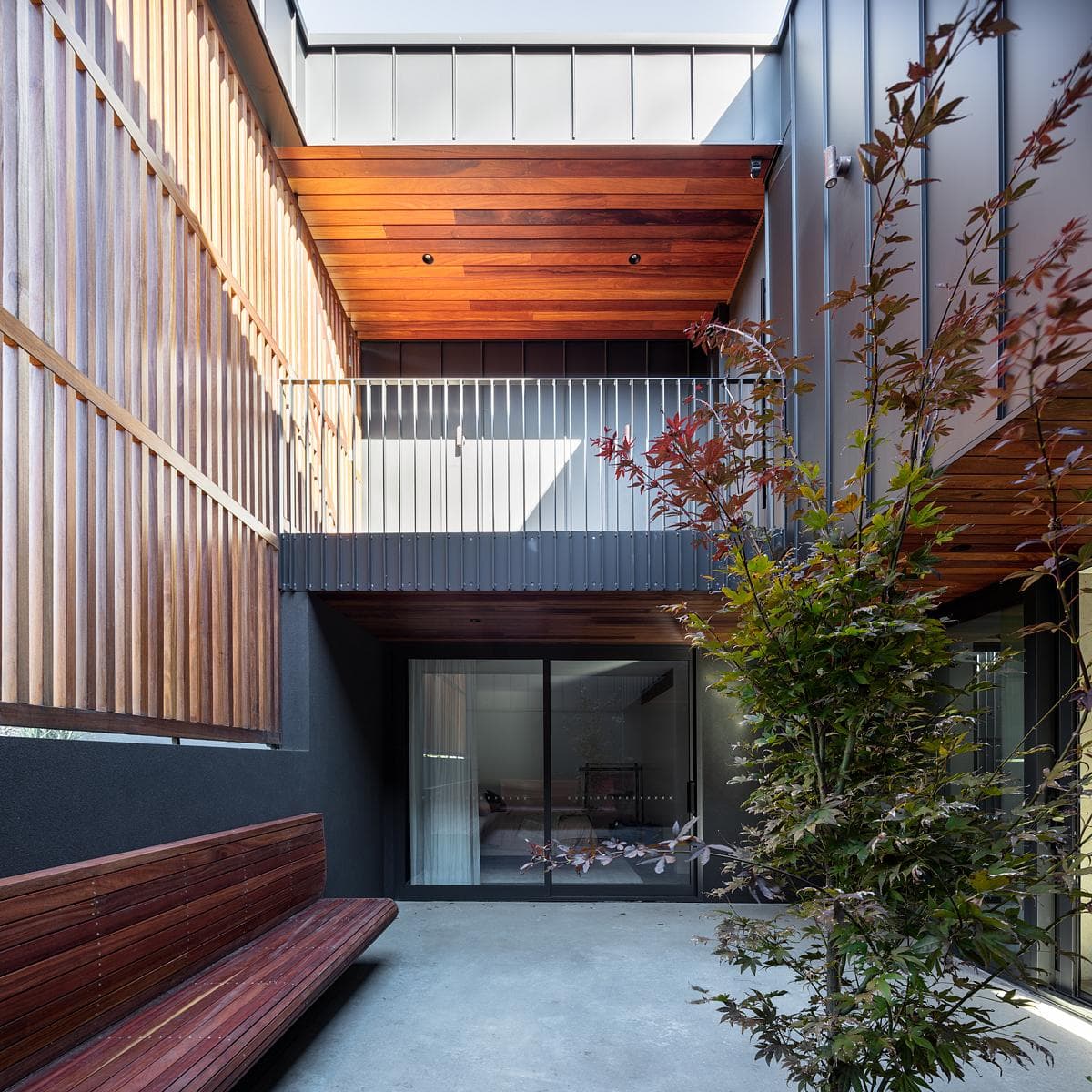 Timber screens and planting enclose a courtyard.