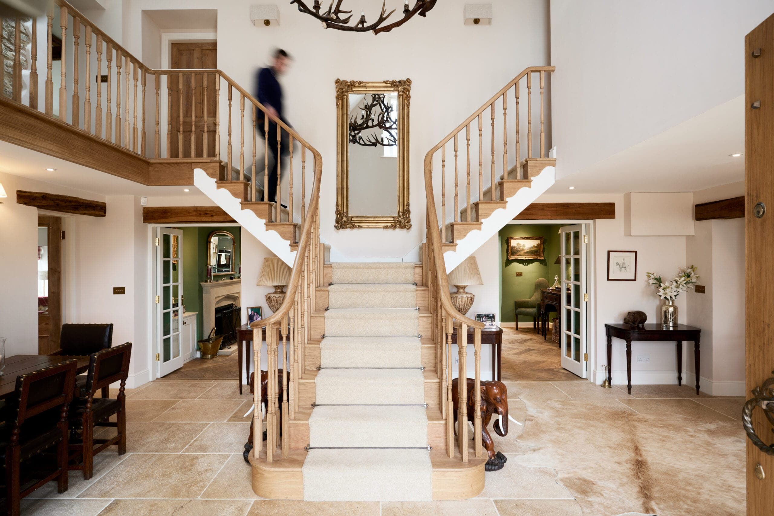 Double-height entrance hall with a curved oak staircase and gallery landing